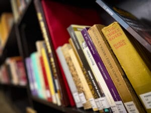 Angled view of a University of Tulsa library shelf displaying English-language and Spanish editions of works by Vicente Blasco Ibáñez (Vicente Blasco Ibanez), preserved within a scholarly archive dedicated to international modernist literature. Prominent volumes include The Three Roses, Mare Nostrum, La Catedral, Arroz y Tartana, and critical studies surrounding Blasco Ibáñez’s political, literary, and transatlantic legacy. The image captures aged cloth bindings, publisher stamps, and archival call numbers, emphasizing the University of Tulsa’s role as a major research archive for Blasco Ibáñez studies, early 20th-century Spanish realism, and the global reception of his novels in English translation.