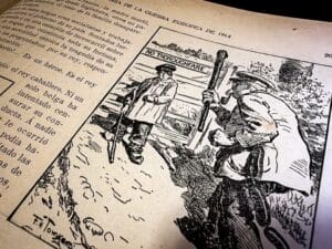 Archival photograph of an illustrated page from Arte y Libertad depicting a wartime scene labeled “Historia de la guerra europea de 1914,” showing armed figures near a barricade marked “No Thoroughfare,” surrounded by historical commentary, preserved in a university archive highlighting visual representations of World War I and the political perspectives associated with Vicente Blasco Ibáñez and Vicente Blasco Ibanez.