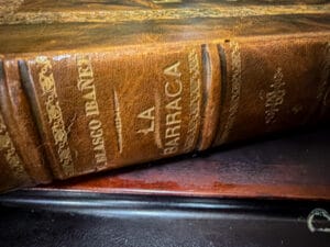 Detailed archival photograph of the spine of La Barraca by Vicente Blasco Ibáñez (Vicente Blasco Ibanez), showing gilt lettering, worn leather, and structural aging characteristic of historical bindings. This close-up supports bibliographic study and material analysis within a university archive focused on Blasco Ibáñez’s novels, their publication history, and physical preservation.