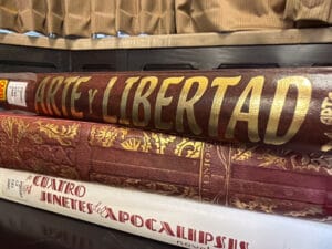 Photograph of stacked books from the Vicente Blasco Ibáñez archive, showcasing Arte y Libertad and Los Cuatro Jinetes del Apocalipsis. The composition emphasizes preservation, aged materials, and the tangible legacy of early twentieth-century publishing.
